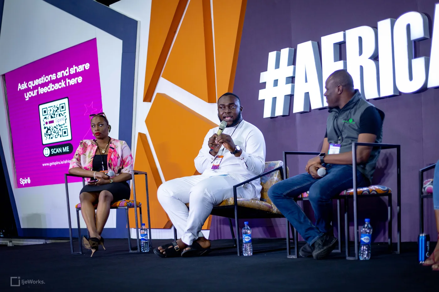 Charles speaking into a microphone on a panel at Afrinext
