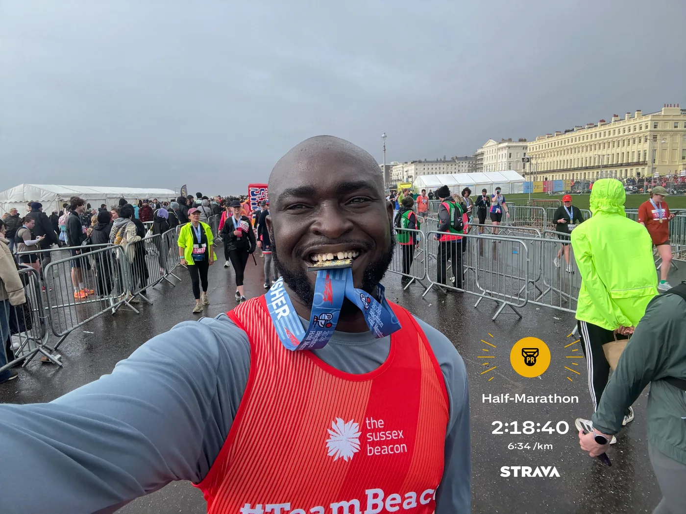 Charles celebrating with his finisher medal at Brighton, wearing a Sussex Beacon running vest
